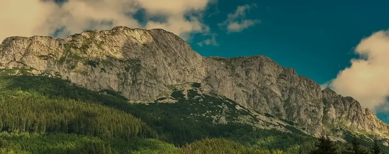Atracții turistice și trasee montane în jurul Casei Iulian: peisaj spectaculos cu Munții Bucegi, vizibil din Moieciu de Sus.